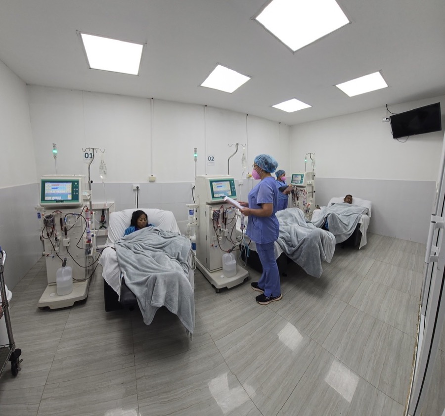 Die Dialysestation im Hospital mit drei Dialysegeräten, Patientinnen und Patienten in den Betten und einer Pflegerin